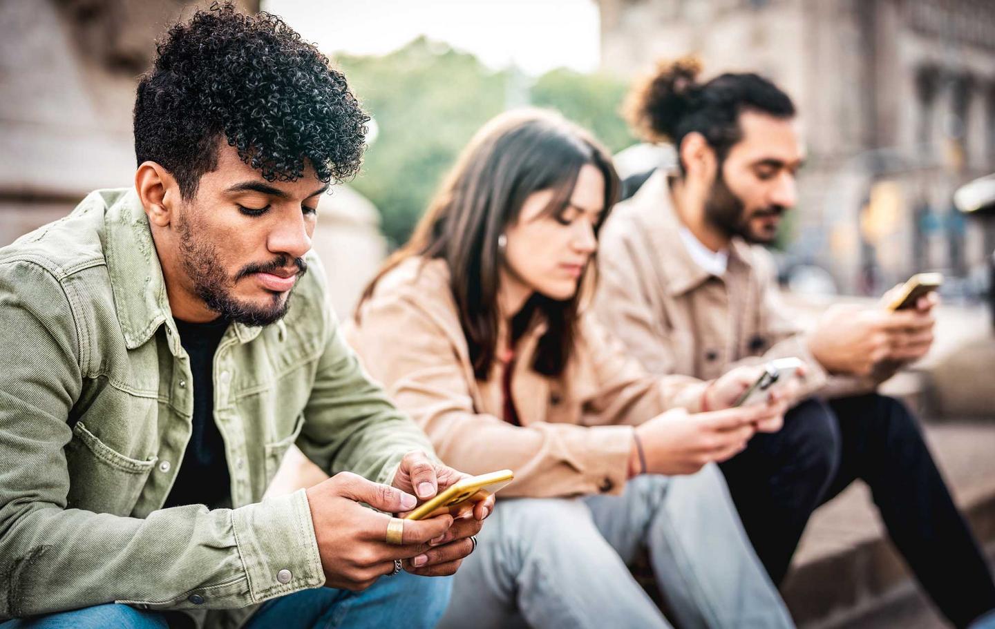 Gruppe junger Leute jeder schaut auf sein Smartphone