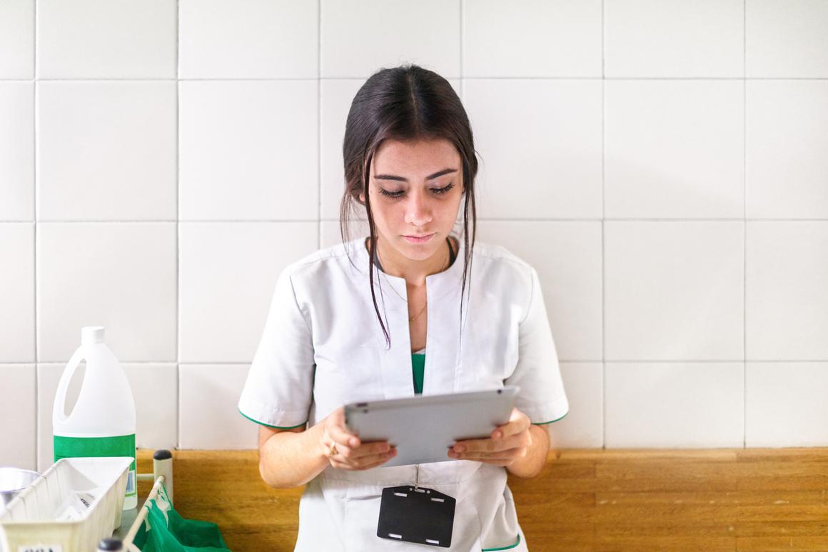Bildnachweis: © stocksy.com / Protonic Ltd Krankenschwester schaut auf ein Tablet
