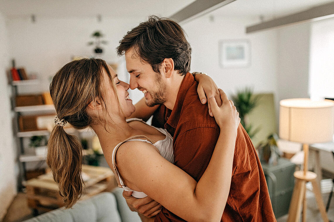 Paar umarmt sich in seiner Wohnung