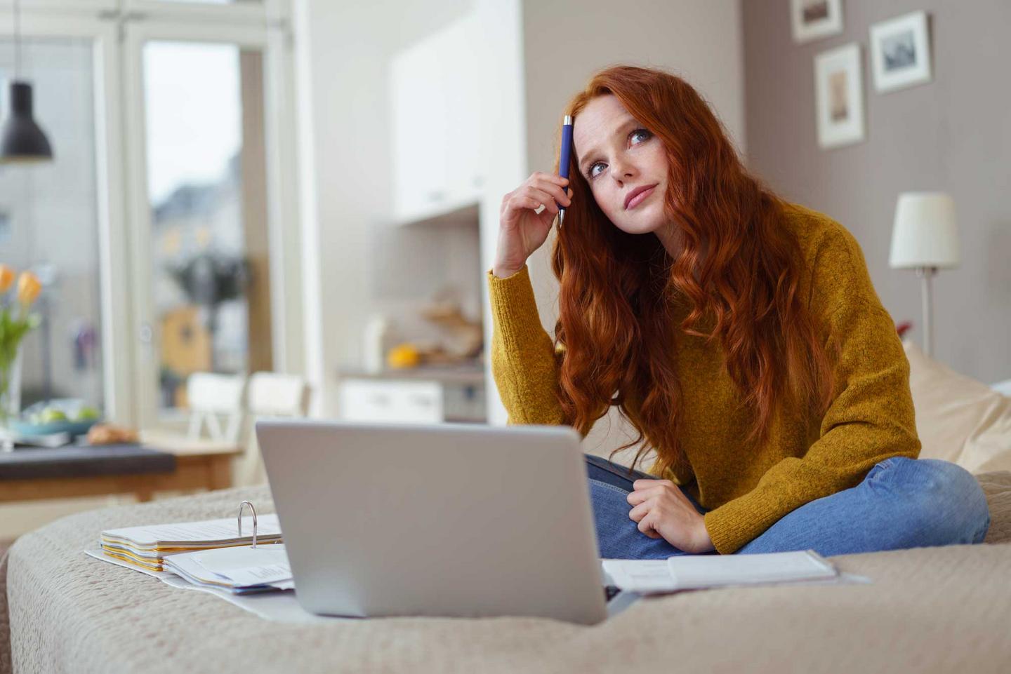 Frau sitzt nachdenklich vor ihrem Laptop